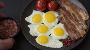 Yağda yumurta, domuz pastırması ve domatesli, tuzlu, baharatlı ve otlu nefis bir kahvaltı.