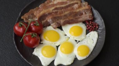 Yağda yumurta, domuz pastırması ve domatesli, tuzlu, baharatlı ve otlu nefis bir kahvaltı.