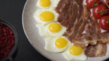 Yağda yumurta, domuz pastırması ve domatesli, tuzlu, baharatlı ve otlu nefis bir kahvaltı.
