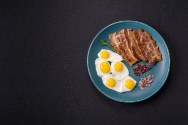 Yağda yumurta, domuz pastırması ve domatesli, tuzlu, baharatlı ve otlu nefis bir kahvaltı.