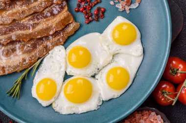 Yağda yumurta, domuz pastırması ve domatesli, tuzlu, baharatlı ve otlu nefis bir kahvaltı.