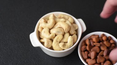 Koyu beton arka planda seramik kasede lezzetli, besleyici fındıklar.