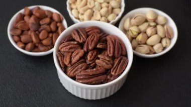 Koyu beton arka planda seramik kasede lezzetli, besleyici cevizler.