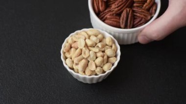 Koyu beton arka planda seramik kasede lezzetli besleyici fıstık.