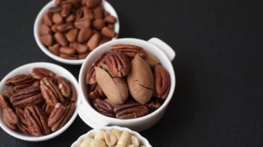 Koyu beton arka planda seramik kasede lezzetli, besleyici cevizler.