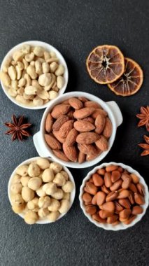 Koyu beton arka planda seramik kasede lezzetli, besleyici badem fıstıkları.