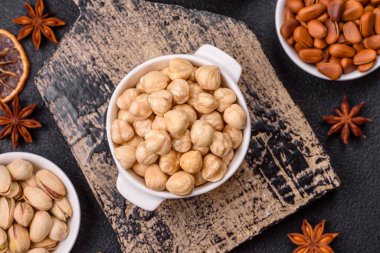 Koyu beton arka planda seramik kasede lezzetli besleyici fındık.