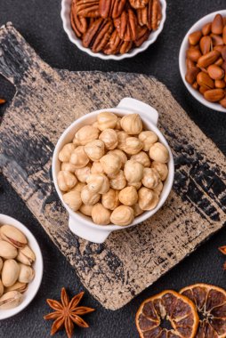 Koyu beton arka planda seramik kasede lezzetli besleyici fındık.