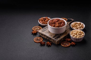 Koyu beton arka planda seramik kasede lezzetli, besleyici cevizler.