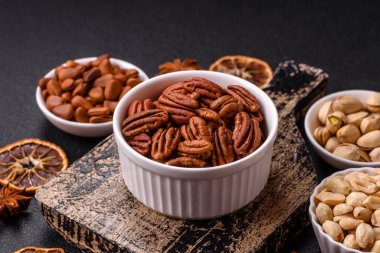 Koyu beton arka planda seramik kasede lezzetli, besleyici cevizler.