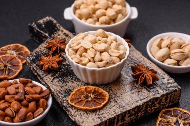 Koyu beton arka planda seramik kasede lezzetli besleyici fıstık.