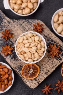 Koyu beton arka planda seramik kasede lezzetli besleyici fıstık.