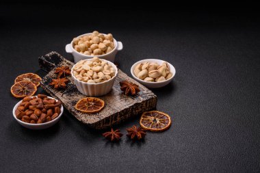 Koyu beton arka planda seramik kasede lezzetli besleyici fıstık.