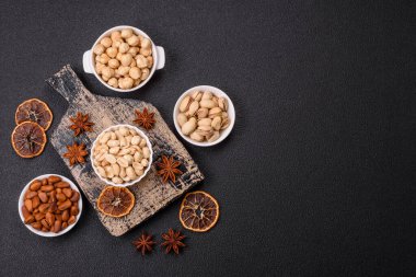 Koyu beton arka planda seramik kasede lezzetli besleyici fıstık.