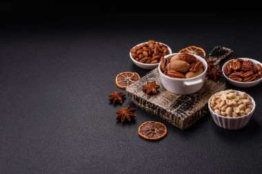 Koyu beton arka planda seramik kasede lezzetli, besleyici cevizler.