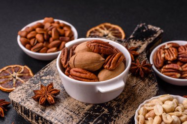 Koyu beton arka planda seramik kasede lezzetli, besleyici cevizler.