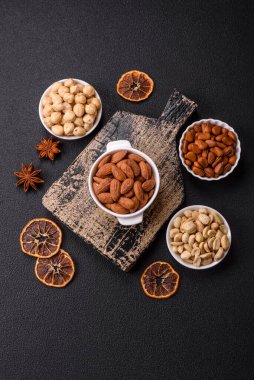 Koyu beton arka planda seramik kasede lezzetli, besleyici badem fıstıkları.