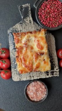 Et, peynir, tuz, baharat ve çimento kaplı lazanya veya makarna.