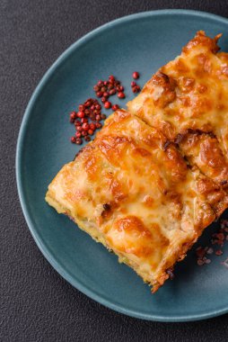 Et, peynir, tuz, baharat ve çimento kaplı lazanya veya makarna.