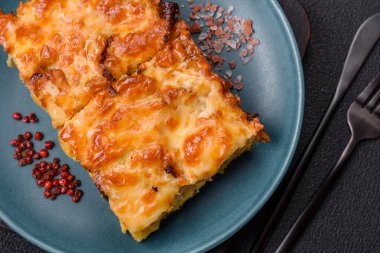 Et, peynir, tuz, baharat ve çimento kaplı lazanya veya makarna.