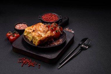 Et, peynir, tuz, baharat ve çimento kaplı lazanya veya makarna.