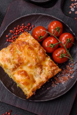 Et, peynir, tuz, baharat ve çimento kaplı lazanya veya makarna.