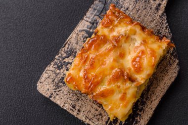 Et, peynir, tuz, baharat ve çimento kaplı lazanya veya makarna.