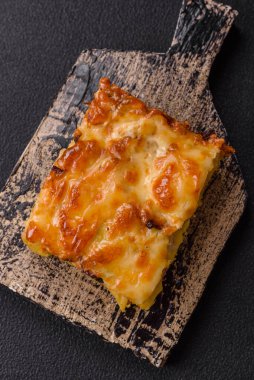 Et, peynir, tuz, baharat ve çimento kaplı lazanya veya makarna.