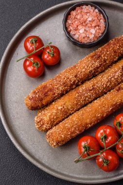 Lula kebabı ateşte kızartılmış, tuzlu, baharatlı ve otlu, koyu beton bir arka planda.