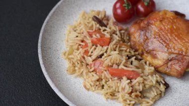 Lezzetli taze pilav, pirinç, havuç, et, soğan, baharat ve böğürtlen ile koyu beton arka planda seramik bir tabakta.