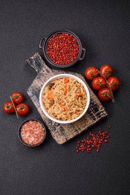 Lezzetli taze pilav, pirinç, havuç, et, soğan, baharat ve böğürtlen ile koyu beton arka planda seramik bir tabakta.