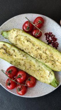 Tuz, baharat ve otlarla pişirilmiş, koyu beton arka planda iki parçaya bölünmüş lezzetli kabak.