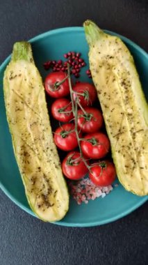 Tuz, baharat ve otlarla pişirilmiş, koyu beton arka planda iki parçaya bölünmüş lezzetli kabak.