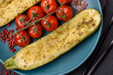 Tuz, baharat ve otlarla pişirilmiş, koyu beton arka planda iki parçaya bölünmüş lezzetli kabak.