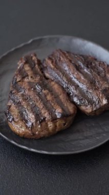 Tuzlu ızgara biftek, baharat ve çimento arka planda otlar.