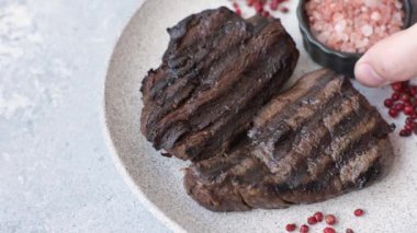 Tuzlu ızgara biftek, baharat ve çimento arka planda otlar.