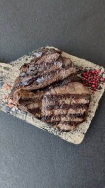 Tuzlu ızgara biftek, baharat ve çimento arka planda otlar.