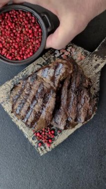 Tuzlu ızgara biftek, baharat ve çimento arka planda otlar.