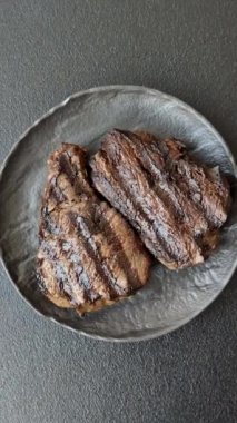 Tuzlu ızgara biftek, baharat ve çimento arka planda otlar.