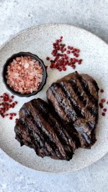 Tuzlu ızgara biftek, baharat ve çimento arka planda otlar.