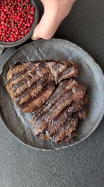 Tuzlu ızgara biftek, baharat ve çimento arka planda otlar.