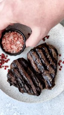 Tuzlu ızgara biftek, baharat ve çimento arka planda otlar.