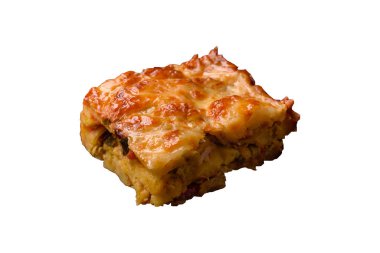 Beyaz arka planda et, peynir, tuz, baharat ve otlarla kaplı lazanya ya da makarna.