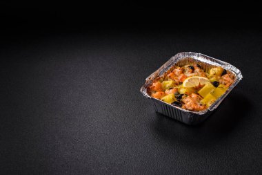 Fırında somon parçaları, patates, peynir ve tuzlu zeytinli, baharatlı ve çimento kaplı.