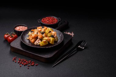 Fırında somon parçaları, patates, peynir ve tuzlu zeytinli, baharatlı ve çimento kaplı.