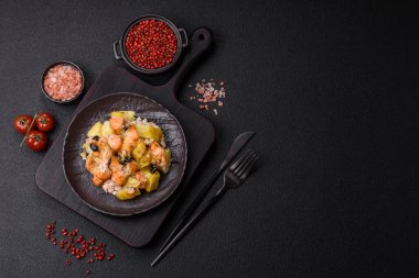 Fırında somon parçaları, patates, peynir ve tuzlu zeytinli, baharatlı ve çimento kaplı.