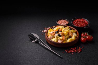 Fırında somon parçaları, patates, peynir ve tuzlu zeytinli, baharatlı ve çimento kaplı.