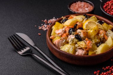 Fırında somon parçaları, patates, peynir ve tuzlu zeytinli, baharatlı ve çimento kaplı.