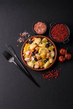 Fırında somon parçaları, patates, peynir ve tuzlu zeytinli, baharatlı ve çimento kaplı.