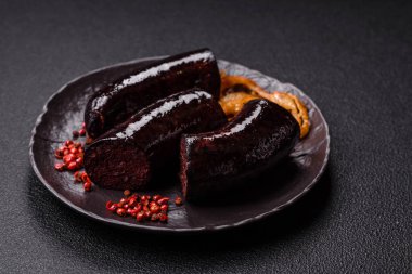 Lezzetli siyah kan sosisi veya siyah beton arka planda ızgara baharat ve otlu kara puding.